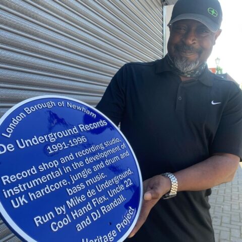 Uncle 22 holding the blue plaque outside 18 Sebert Road