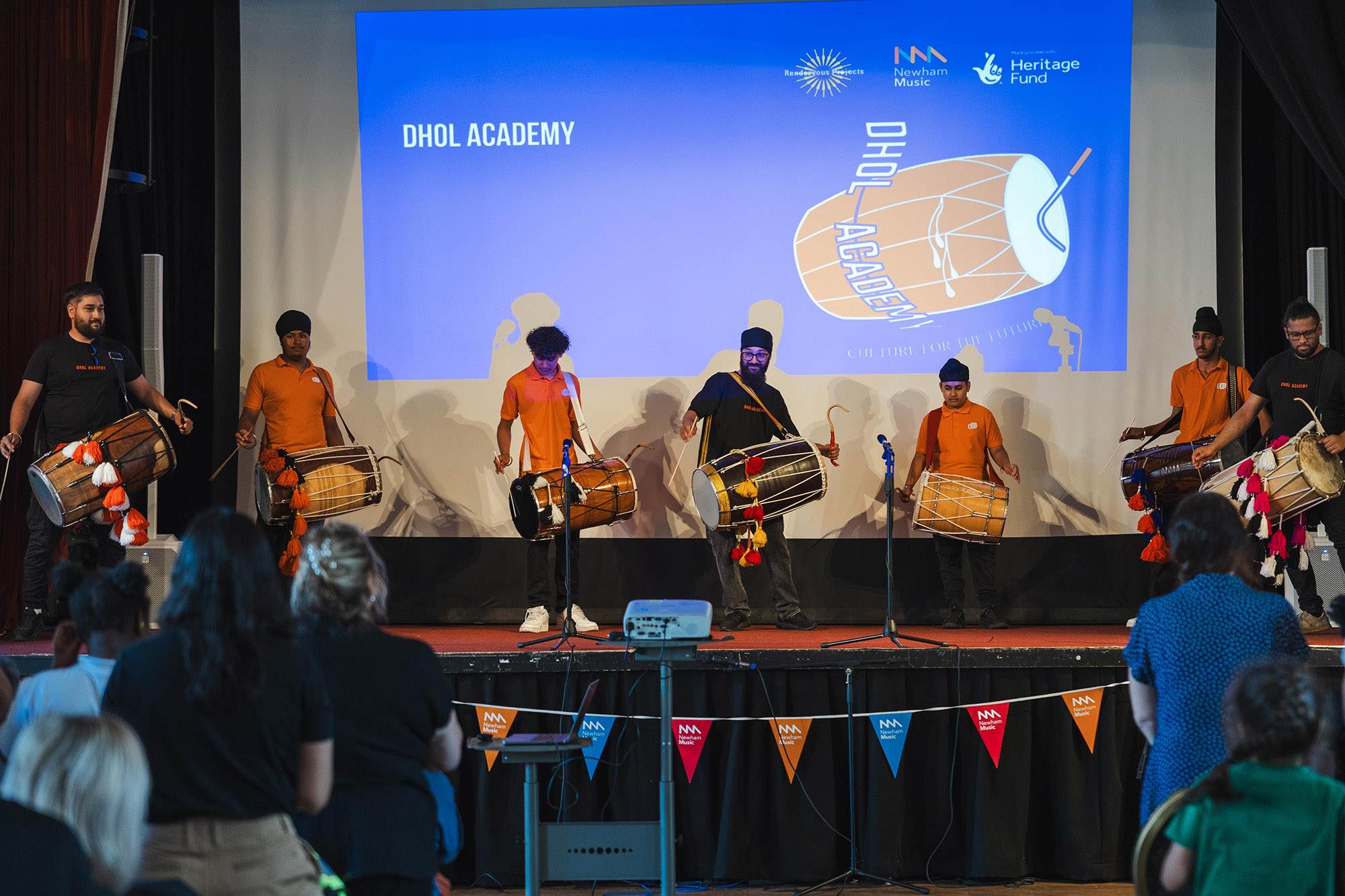 Image of Dhol Drummers playing on a stage