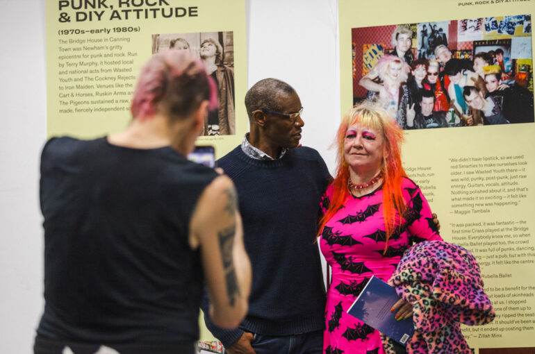 Image of guests standing in front of banners with information about music in Newham on them